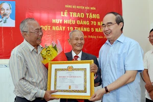 Bí thư Thành ủy TPHCM Nguyễn Thiện Nhân trao Huy hiệu 70 năm tuổi Đảng cho đồng chí Lê Văn Nghị. Ảnh: VIỆT DŨNG