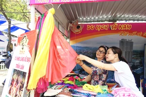 Người tiêu dùng chọn mua khăn choàng tại một hội chợ ở TPHCM