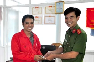Thiếu úy Văn Ngọc Cường trao lại tiền và giấy tờ cho anh Hoàng Trọng Hiếu