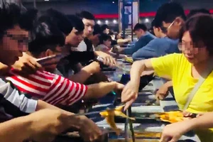 Giới trẻ tranh giành nhau gắp thức ăn tại tiệc buffet miễn phí ở Cần Thơ (ảnh cắt từ clip)