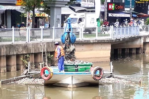 Công nhân vớt rác dưới kênh