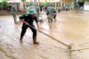 Bộ đội Biên phòng tỉnh Nghệ An giúp dân dựng lại nhà, dọn dẹp trường lớp. Ảnh: DUY CƯỜNG