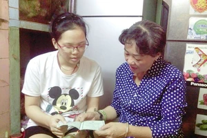 Cô Trần Thị Huỳnh Mai (phải) thăm hỏi, trò chuyện với em Hà Mỹ Nhi