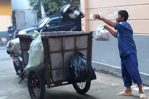 Người thu gom rác dân lập không trang bị bảo hộ lao động với chiếc xe lấy rác rất lạc hậu