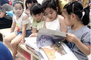 Bạn đọc nhí thích thú cuốn sách Thiện và Ác và Cổ tích - sách Artbook do NXB Kim Đồng ấn hành