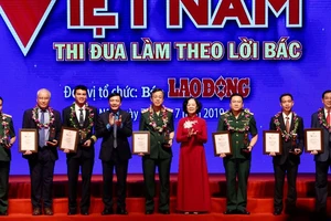 Đồng chí Trương Thị Mai, Ủy viên Bộ Chính trị, Bí thư Trung ương Đảng, Trưởng ban Dân vận Trung ương trao biểu trưng vinh danh các tập thể có thành tích xuất sắc. Ảnh: TTXVN