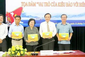 Ông Hoàng Chí Hùng (bìa trái), Chủ nhiệm CLB Ảnh báo chí Hội Nhà báo TPHCM, tặng các đại biểu sách ảnh về biển đảo