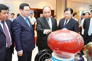 Thủ tướng Nguyễn Xuân Phúc tham quan các gian hàng trưng bày sản phẩm trong khuôn khổ hội nghị Ảnh: VIẾT CHUNG