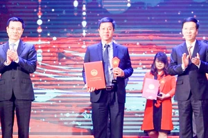 Đồng chí Võ Văn Thưởng và Bộ trưởng Bộ TT-TT Nguyễn Mạnh Hùng trao giải A cho các tác giả đoạt giải. Ảnh: TTXVN