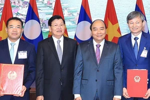 Thủ tướng Nguyễn Xuân Phúc và Thủ tướng Thongloun Sisoulith chứng kiến ký kết hợp đồng mua bán điện giữa Tập đoàn Điện lực Việt Nam và Tập đoàn Phongsubthavy (Lào). Ảnh: TTXVN