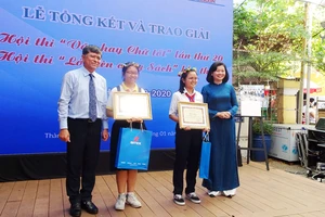 Bà Lý Việt Trung, Phó Tổng biên tập Báo SGGP (ngoài cùng bên phải) và ông Nguyễn Văn Hiếu, Phó Giám đốc Sở GD-ĐT TPHCM (ngoài cùng bên trái) trao thưởng cho 2 học sinh đoạt giải nhất hội thi “Văn hay chữ tốt”