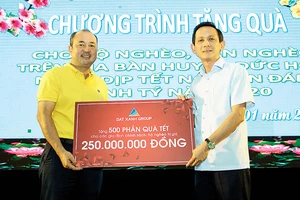Ông Lương Trí Thảo - Phó TGĐ Tập đoàn Đất Xanh (áo vàng, bên trái), đại diện Tập đoàn trao tặng 500 phần quà Tết đến chính quyền huyện Đức Hòa, tỉnh Long An