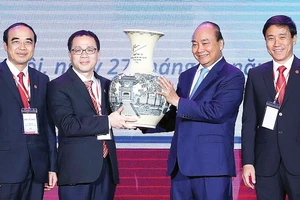 Thủ tướng Nguyễn Xuân Phúc trao quà lưu niệm tặng Trường Đại học Y Hà Nội. Ảnh: TTXVN
