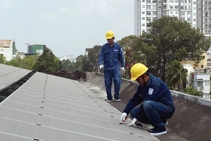 Nhân viên EVNHCMC lắp đặt điện mặt trời trên mái nhà cho một đơn vị thuộc ngành điện lực