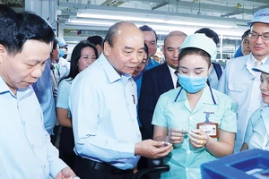 Thủ tướng Nguyễn Xuân Phúc tìm hiểu đời sống công nhân của Công ty TNHH điện tử Foster (Bắc Ninh). Ảnh: TTXVN