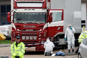 Cảnh sát và nhân viên pháp y tại hiện trường xe container chở 39 thi thể được phát hiện ở Essex, Anh, ngày 23-10-2019. Ảnh: REUTERS