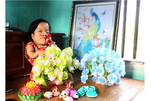 Chị Nguyễn Thị Hòa cùng những bình hoa, bức tranh xinh xắn do chị làm, được cộng đồng mạng chia sẻ