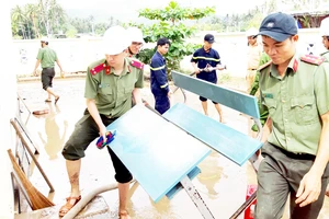 Công an tỉnh Phú Yên giúp người dân thị xã Sông Cầu khắc phục hậu quả bão số 12. Ảnh: XUÂN HUYÊN