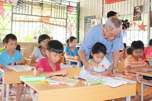 Ông giáo Ngô Tùng Bích đang luyện chữ cho học sinh nghèo vùng biên