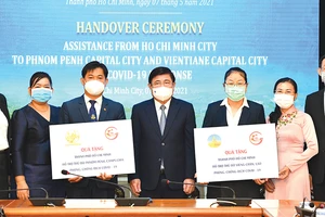 Chủ tịch UBND TPHCM Nguyễn Thành Phong trao quà hỗ trợ Vientiane và Phnom Penh. Ảnh: VIỆT DŨNG