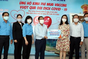 Ông Dương Hồng Nhân, Chủ tịch Hội đồng thành viên Sawaco, thay mặt người lao động tổng công ty trao tiền ủng hộ mua vaccine Covid-19