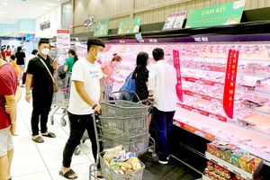 Người dân đeo khẩu trang khi đi siêu thị tối 27-5. Ảnh: CAO THĂNG