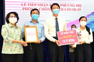 Chủ tịch Ủy ban MTTQ Việt Nam TPHCM Tô Thị Bích Châu (trái) tiếp nhận đóng góp của tập đoàn CT&D ủng hộ kinh phí mua vaccine phòng chống dịch Covid-19. Ảnh: VIỆT DŨNG