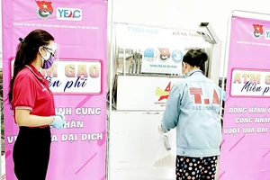 Thanh niên công nhân nhận gạo tại cây ATM gạo của chương trình