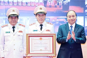 Chủ tịch nước Nguyễn Xuân Phúc trao tặng Huân chương Bảo vệ Tổ quốc hạng nhất cho lực lượng An ninh nhân dân. Ảnh: TTXVN