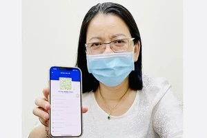 Phó Giám đốc Sở TT-TT TPHCM Võ Thị Trung Trinh với mã QR xanh trên ứng dụng Y tế HCM