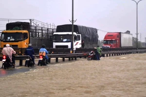 Nước lũ tràn qua Quốc lộ 1A, đoạn thuộc huyện Phú Ninh, tỉnh Quảng Nam. Ảnh: NGUYỄN CƯỜNG