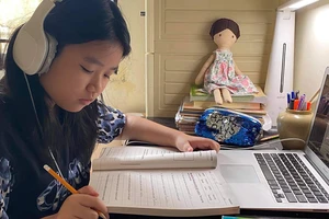 Em Khánh An (quận 8) đang tập trung theo bài học khi học trực tuyến tại nhà. Ảnh: HOÀNG HÙNG