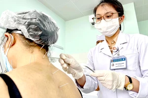 ThS-BS Trần Thị Đài Trang, khoa Nội cơ xương khớp Bệnh viện Y học cổ truyền TPHCM châm cứu cho bệnh nhân điều trị hậu Covid-19. Ảnh: HOÀNG HÙNG