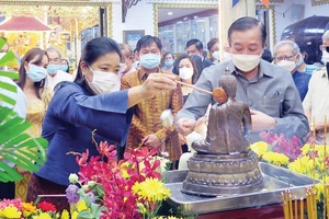 Bà Wiraka Mudhitaporn, Tổng lãnh sự Thái Lan tại TPHCM (trái), thực hiện nghi thức tắm Phật tại lễ hội. Ảnh: TTXVN