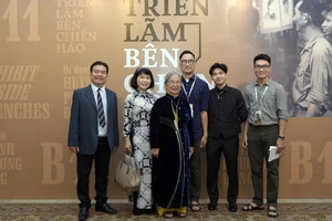 Hoàng Việt (giữa) và Hùng Cường (bên phải ngoài cùng) cùng gia đình hoạ sĩ Huỳnh Phương Đông tại buổi triển lãm. Ảnh: BTC