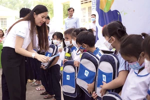 Bà Trần Kim Ngân - Giám đốc truyền thông Tập đoàn Xây dựng Hòa Bình đang trao cặp cho các em học sinh
