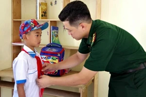Cán bộ Đồn biên phòng Phú Gia chuẩn bị đồng phục cho em Lê Văn Hoàng đến trường