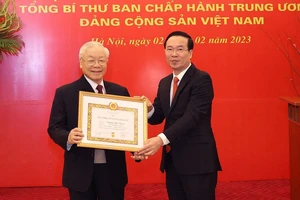 Đồng chí Võ Văn Thưởng trao Huy hiệu 55 năm tuổi Đảng tặng Tổng Bí thư Nguyễn Phú Trọng. Ảnh: TTXVN