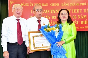 Chủ tịch HĐND TPHCM Nguyễn Thị Lệ và Trưởng Ban Tuyên Giáo Thành ủy TPHCM trao Huy hiệu 60 năm tuổi Đảng cho đồng chí Võ Văn Cương. Ảnh: VIỆT DŨNG