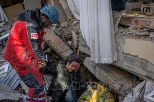 Nhân viên cứu hộ giải cứu anh trai ra khỏi đống đổ nát sau trận động đất ở Hatay, Thổ Nhĩ Kỳ, ngày 8-2-2023. Ảnh: TTXVN