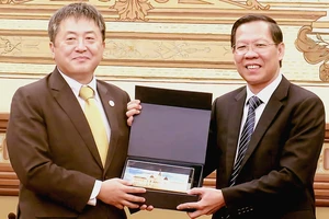 Chủ tịch UBND TPHCM Phan Văn Mãi tặng quà lưu niệm ông Shimizu Akira, Trưởng Đại diện Văn phòng JICA Việt Nam tại buổi tiếp. Ảnh: MINH HIỆP
