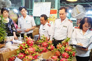 Lực lượng chức năng kiểm tra an toàn thực phẩm tại chợ đầu mối nông sản Thủ Đức. Ảnh: HOÀNG HÙNG