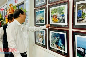 Phó Bí thư Thành ủy TPHCM Nguyễn Hồ Hải tham quan triển lãm ảnh thời sự nghệ thuật. Ảnh: CHÍ THẠCH