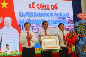 Ông Trương Cảnh Tuyên (bìa trái), Phó Chủ tịch Thường trực UBND tỉnh Hậu Giang trao bằng công nhận xã nông thôn mới kiểu mẫu cho lãnh đạo xã Đại Thành