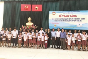 Ông Lê Văn Công, Kiểm Soát viên Công ty TNHH Một thành viên Xổ số kiến thiết TP Hồ Chí Minh cùng với lãnh đạo UBMTTQ TP, UBMTTQ huyện Nhà Bè và đơn vị Tài trợ chụp hình lưu niệm cùng với các em học sinh, sinh viên nhận học bổng