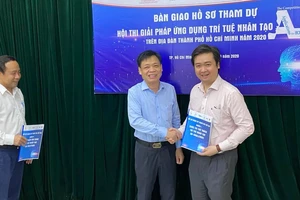 Ông Lê Quốc Cường, Phó Giám đốc Sở TT-TT TPHCM (giữa) trao bài dự thi hội thi cho đại diện ban giám khảo
