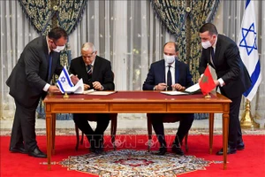 Các đại diện của Morocco và Israel ký thỏa thuận thiết lập quan hệ ngoại giao tại Rabat, Morocco ngày 22-12. Ảnh: AFP/TTXVN