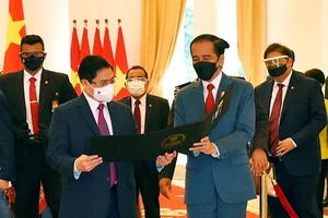 Tổng thống Indonesia Joko Widodo thân tặng Thủ tướng Phạm Minh Chính tấm hình kỷ niệm cuộc gặp đầu tiên trên cương vị Thủ tướng. Ảnh: VGP