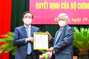 Chủ tịch Ủy ban Trung ương MTTQ Việt Nam Đỗ Văn Chiến (phải) trao quyết định cho đồng chí Lương Quốc Đoàn. Ảnh: TTXVN