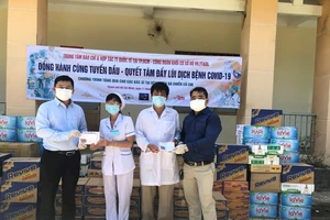 Giám đốc Trung tâm Báo chí và hợp tác truyền thông quốc tế tại TPHCM Lê Tự Phương Quang (trái) cùng mạnh thường quân trao quà hỗ trợ đội ngũ y, bác sĩ, các nhân viên y tế